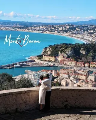 a man and woman standing on a wall looking at a city at Spacious apartment in Cimiez in Nice