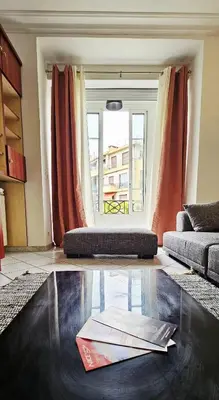 a living room with a couch and a window at Spacious apartment in Cimiez in Nice
