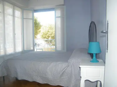 a bedroom with a bed with a blue lamp on a table at Apartment Villa HenriIV in Nice