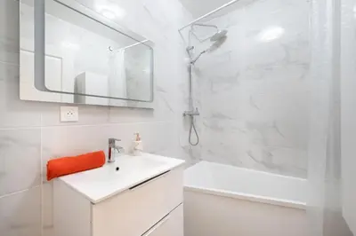 a white bathroom with a sink and a shower at Azur Stay 3 Start Beach 8 min Tram Airport 5m in Nice