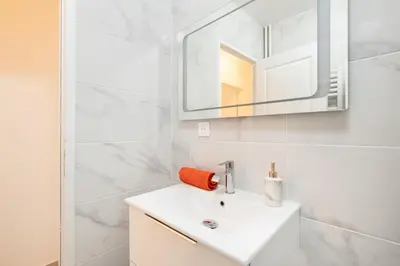 a white bathroom with a sink and a mirror at Azur Stay 3 Start Beach 8 min Tram Airport 5m in Nice