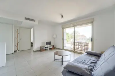a living room with a couch and a table at Lovely 1BR with garden, private parking & Sea View in Nice