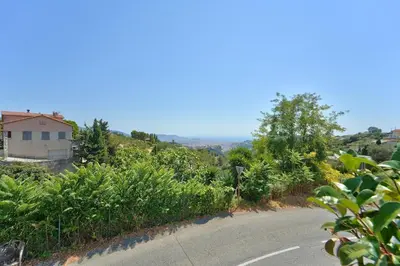 an empty road with a house on a hill at Lovely 1BR with garden, private parking & Sea View in Nice