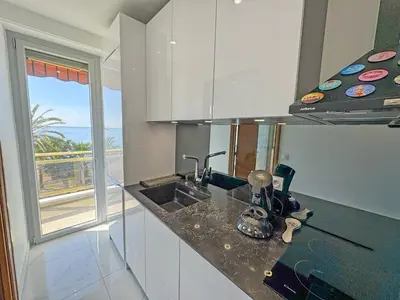 a kitchen with white cabinets and a sink at Riviera Escape Promenade Nice in Nice