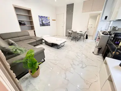 a living room with a couch and a table at Bright, Central & Stylish 3 Min Walk to the Sea in Nice