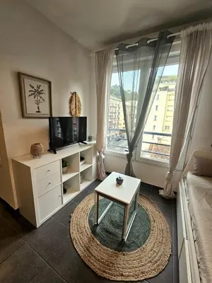 a living room with a tv and a coffee table at Charming studio in Nice