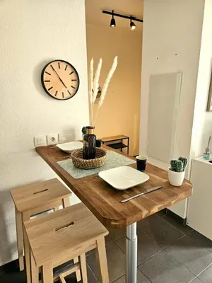 a table with two chairs and a clock on the wall at Charming studio in Nice