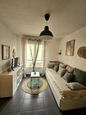 a living room with a couch and a table at Charming studio in Nice