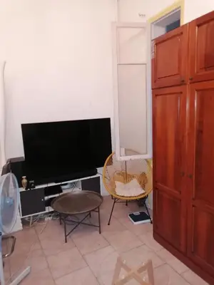 a living room with a flat screen tv and a chair at Teranga in Nice