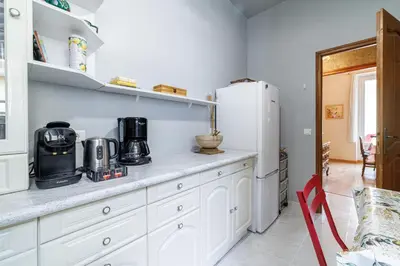 a kitchen with white cabinets and a white refrigerator at La Terrasse de Bracco in Beaulieu-sur-Mer