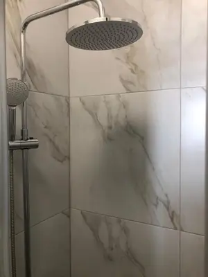 a bathroom with a shower with marble walls and a light at Le St Lambert, Grand Studio Libération in Nice