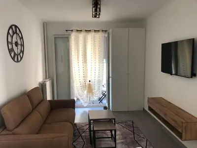a living room with a couch and a television at Le St Lambert, Grand Studio Libération in Nice