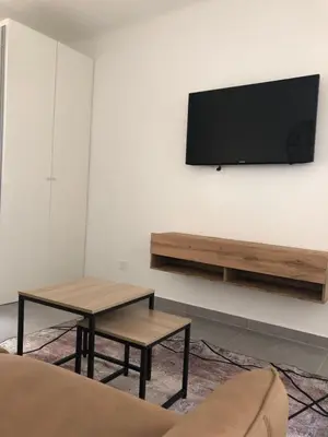 a living room with two tables and a tv on a wall at Le St Lambert, Grand Studio Libération in Nice