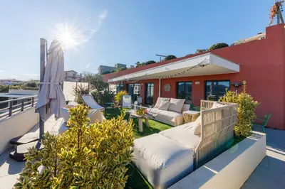 a patio with a couch and a table on a balcony at Green Hill Appartement à Nice Terrasse 130m2, Vue panoramique, Piscine, Parking Privé, Climatisation, WiFi in Nice