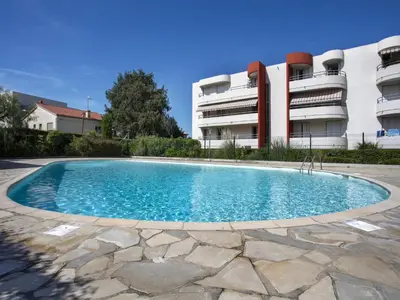 a swimming pool in front of a building at Studio Le Bali by Interhome in Cagnes-sur-Mer