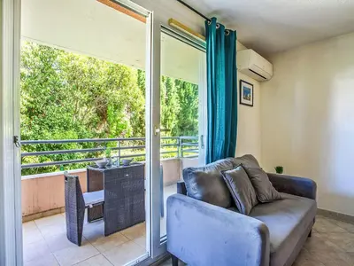 a living room with a couch and a sliding glass door at Studio Le Bali by Interhome in Cagnes-sur-Mer