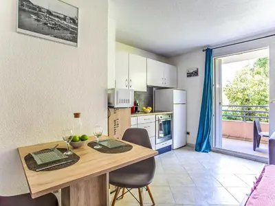 a kitchen with a table and chairs and a dining room at Studio Le Bali by Interhome in Cagnes-sur-Mer
