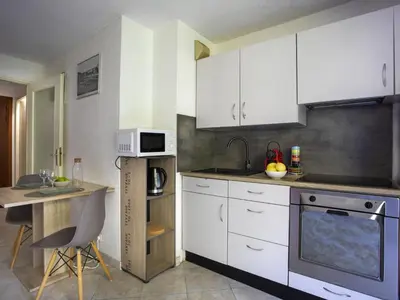 a kitchen with white cabinets and a counter top at Studio Le Bali by Interhome in Cagnes-sur-Mer