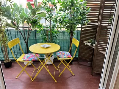 a yellow table and chairs sitting on a patio at Bel appartement spacieux avec joli balcon arboré, calme, bien situé, centre ville in Nice
