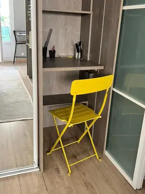 a yellow chair sitting in front of a desk at Bel appartement spacieux avec joli balcon arboré, calme, bien situé, centre ville in Nice