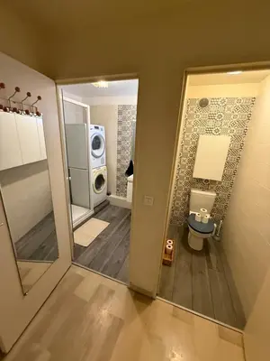 a bathroom with a shower and a sink and a washing machine at Cosy appartement, terrasse in Nice