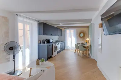a kitchen and living room with blue cabinets and a table at AUTHENTIC VILLEFRANCHE AP4472 By Riviera Holiday Homes in Villefranche-sur-Mer