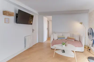 a white living room with a couch and a table at AUTHENTIC VILLEFRANCHE AP4472 By Riviera Holiday Homes in Villefranche-sur-Mer