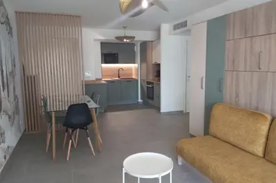 a living room with a couch and a table at Seafront apartment with pool and comfort in Saint-Laurent-du-Var