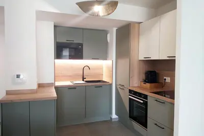 a small kitchen with a sink and a stove at Seafront apartment with pool and comfort in Saint-Laurent-du-Var