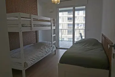 a bedroom with bunk beds and a large window at Seafront apartment with pool and comfort in Saint-Laurent-du-Var