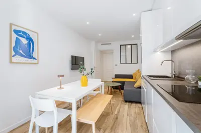 a kitchen and living room with a white table and chairs at Nice Renting - REPUBLIQUE - Garibaldi Chic 3 Bedrooms 3 Bathrooms Balcony AirCon in Nice