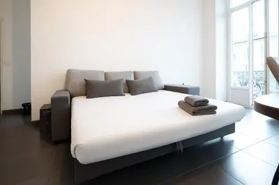 a bedroom with a large white bed with towels on it at Le Malausséna in Nice