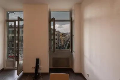 a room with two windows and a view of a city at Le Malausséna in Nice