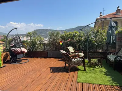 a deck with chairs and a table on a house at Terrasse de Cimiez in Nice