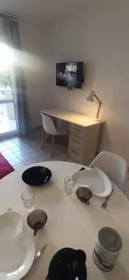 a table with plates and utensils on top of it at Studio climatisation balcon à 5 min de la plage in Nice
