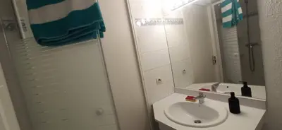 a white bathroom with a sink and a mirror at Studio climatisation balcon à 5 min de la plage in Nice