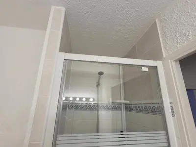 a glass door in a room with a ceiling at Studio climatisation balcon à 5 min de la plage in Nice
