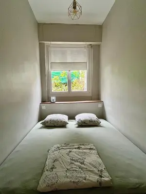 a bed with two pillows in a room with a window at Jeanne Darc in Nice