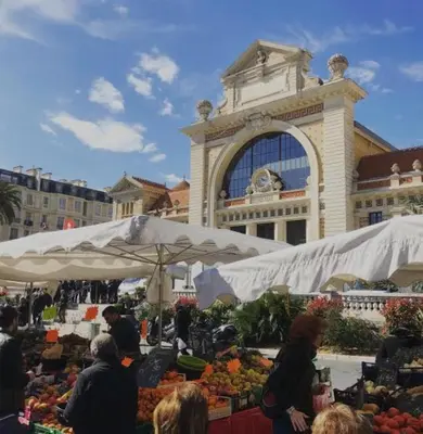 a market in front of a large building with people standing around at Jeanne Darc in Nice