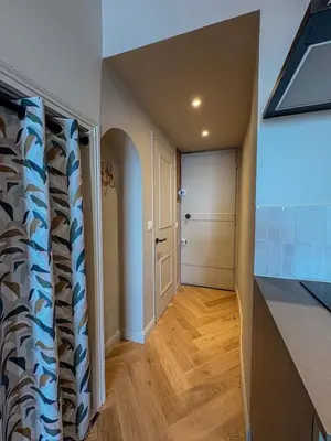 a hallway leading to a kitchen with a door at Charmant 2 pièces rénové avec vue mer in Villefranche-sur-Mer