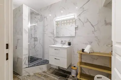 a white bathroom with a shower and a sink at Ultra Central Rue Massena 1 Bdr in Nice