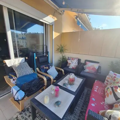 a balcony with a table and chairs and a couch at Magnifique appartement a la mer in Nice