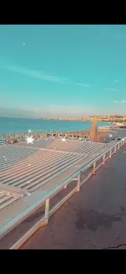 a row of benches on a beach with the ocean at Magnifique appartement a la mer in Nice