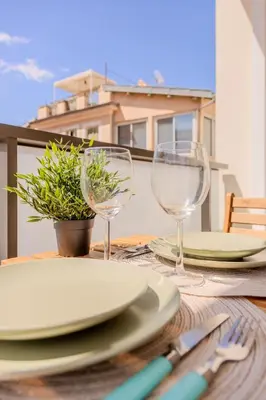 a table with plates and wine glasses on it at Nice 2 pièces charmant proche port et transports in Nice