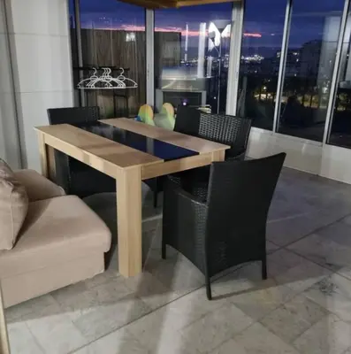 a dining table and chairs in a room with a window at Logement vue mer - Nice ouest in Nice