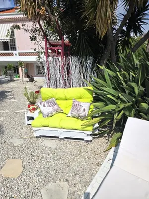 a yellow couch sitting on the ground in a yard at Villa le Mazet, Nice, piscine, vue mer, Promenade des Anglais, Baie des Anges in Nice