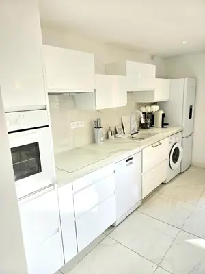 a white kitchen with white cabinets and a dishwasher at Villa le Mazet, Nice, piscine, vue mer, Promenade des Anglais, Baie des Anges in Nice