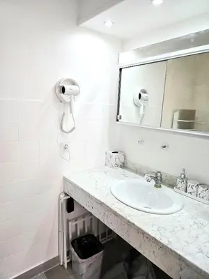 a white bathroom with a sink and a mirror at Villa le Mazet, Nice, piscine, vue mer, Promenade des Anglais, Baie des Anges in Nice