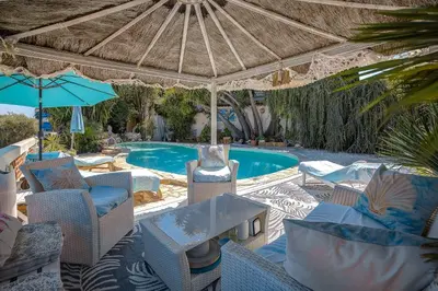 a patio with chairs and a swimming pool with an umbrella at Villa le Mazet, Nice, piscine, vue mer, Promenade des Anglais, Baie des Anges in Nice