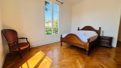 a bedroom with a bed and a chair and a window at Sublime 2 bedroom spacious and bright AC Private parking in Nice